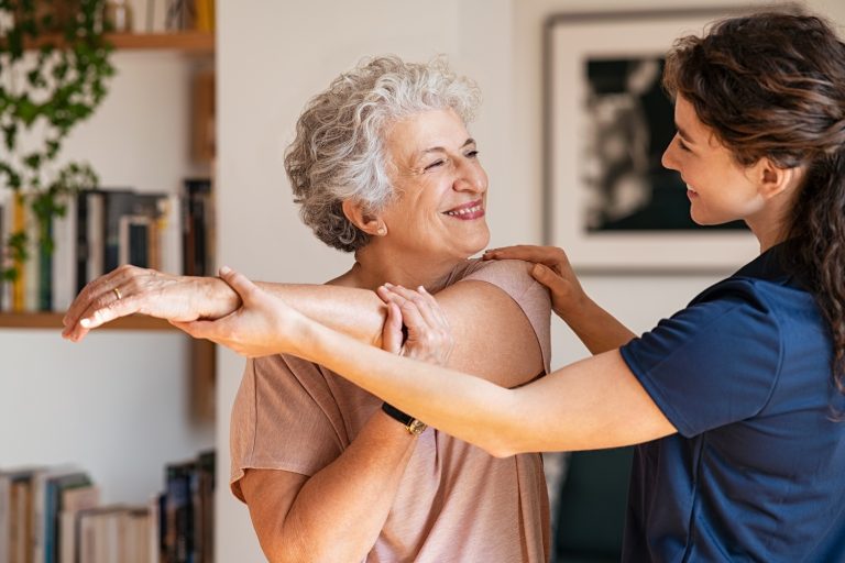 Senior woman with trainer exercising at home